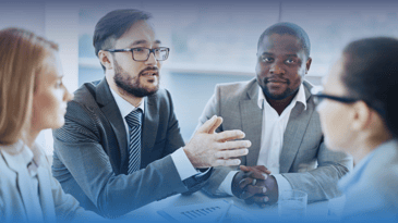 Two men seated at an office table discussing Claro