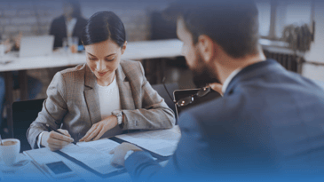 A woman and man reviewing documents in an office