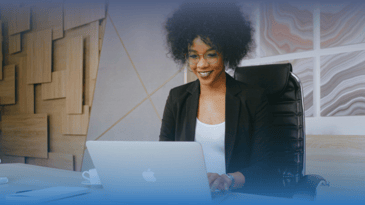 Black woman in an office on her laptop listening to an AI webinar