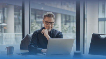 Mature businessman watching LinkedIn Live on laptop.